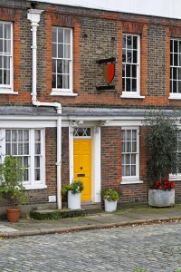 Old English house with brick wall and yellow door